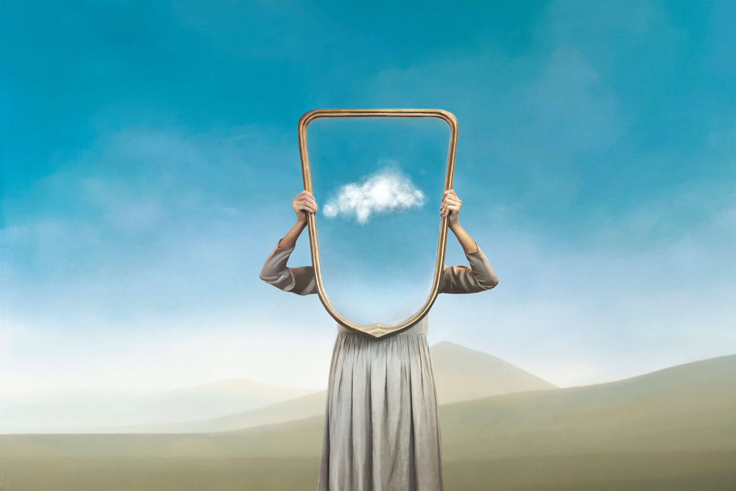 the woman hides holding a mirror in front of her face; introspection path concept